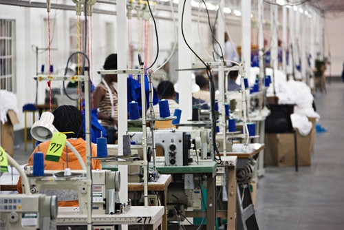 A look inside a large factory where many employees are working to manufacture diverse products.