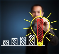 Man painting a lightbulb representing an idea that will help spike growth in his business.