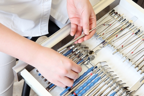 A man searches through multiple folder inside a filing cabinet.