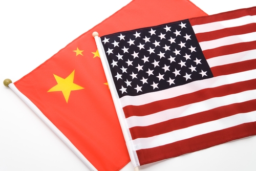 An American flag lays on top of a Chinese flag