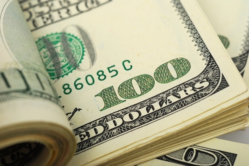 A picture of many 100 dollar bills being flipped through, like a book.