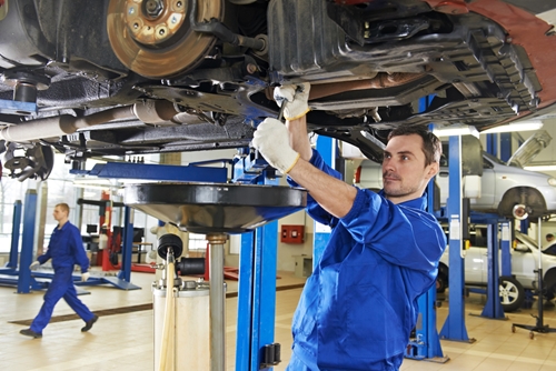 A mexican employee works in an auto manufacturing facility where he helps operate dome of the automated machinery.