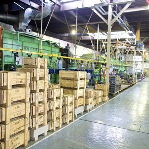A picture of a large warehouse where many wooden boxes store manufactured goods.