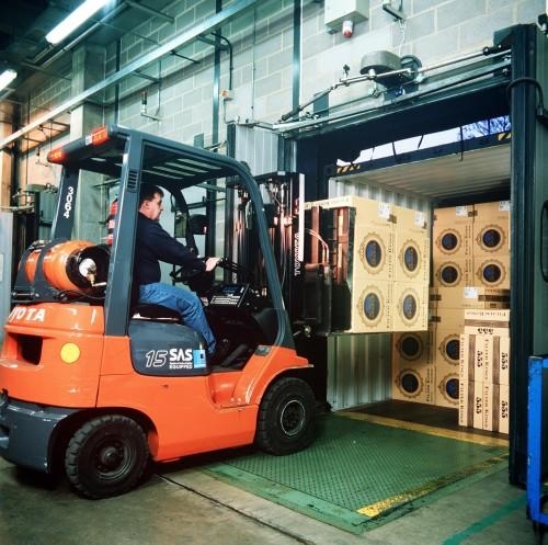 A small vehicle helps to move boxes inside a warehouse from one spot to another.