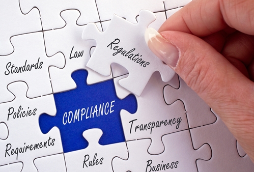Picture on a puzzle showing words like regulations, policies, compliance, etc.