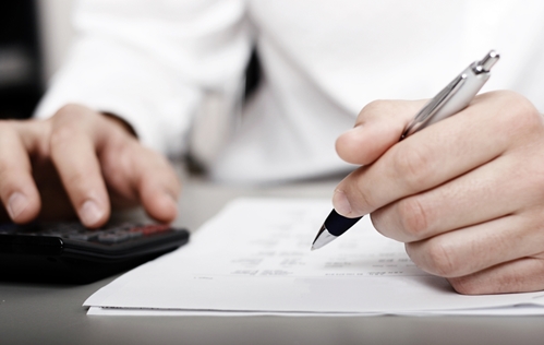 There is a man with a white button down shirt working to write up a deal.