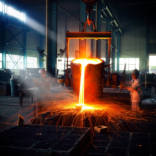 In a factory, employees pour hot metal into molds to begin manufacturing their goods.