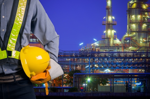A factory employee looking over the entire manufacturing plant.