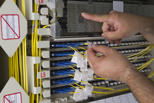 An employee working to manufacture electronic components used in electronic manufactured goods.