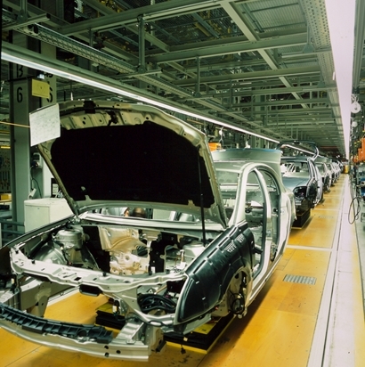 The shell or fram of a car is being build by robotic automated structures in a Mexican factory.