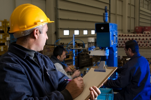 A mexican employee working to supervise all of the operations within the manufacturing facility.