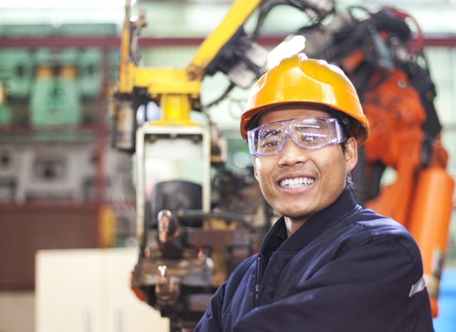 Happy Mexican employee working inside of a manufacturing facility in Mexico.