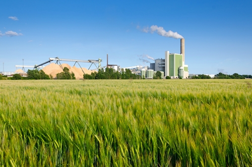 A large manufacturing plant stands in the middle of a large green field in Mexico.