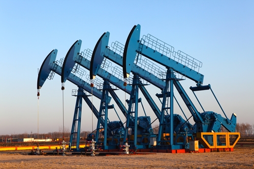 There a several pieces of large machinery that are drilling oil out of the ground in Mexico.