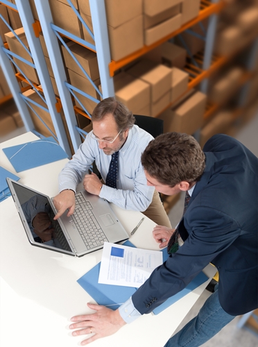 A picture of two executives discussing work issues inside a large warehouse.