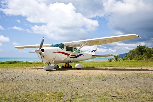 A view at a small aircraft that is still on the floor with a beautiful landscape in Mexico as the background.