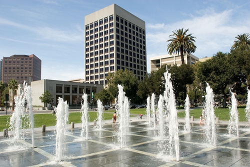 There is a large fountain in front of an industrial ares in the middle of San Jose.