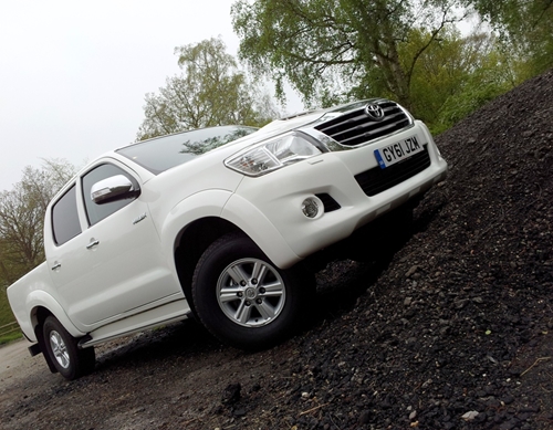 There is a picture of a large white toyota pick up truck on the side of the road in Mexico.