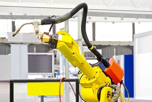 An automated robotic arm works to assemble various new products in a factory in Mexico.